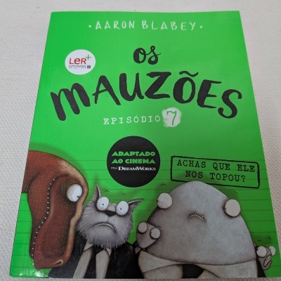 Capa de livro infantil verde com personagens caricatos e texto em português.