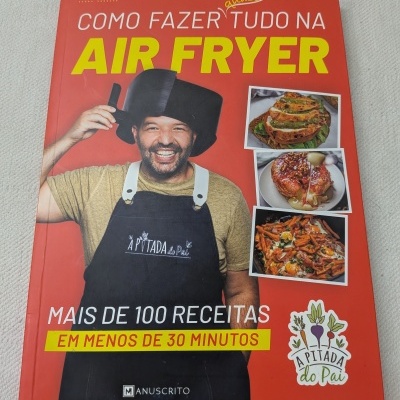 Capa do livro de receitas sobre Air Fryer com homem usando avental e fotos de pratos.