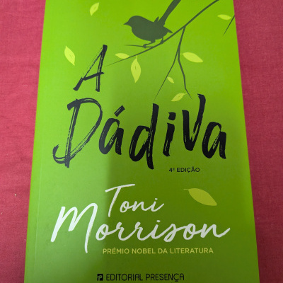 Livro verde com pássaro preto e texto em português.
