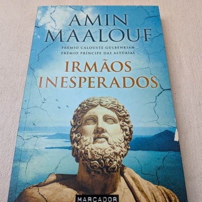 Livro com capa azul e imagem de estátua clássica com barba