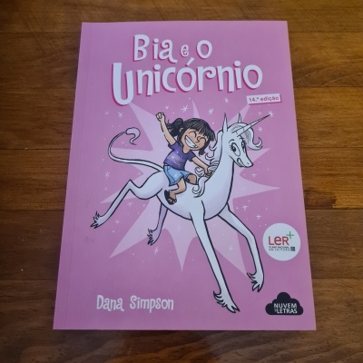Capa de livro rosa com rapariga e unicórnio branco ilustrados