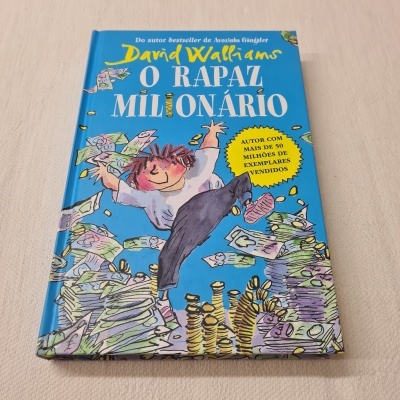 Capa de livro azul com ilustração de rapaz e notas de dinheiro