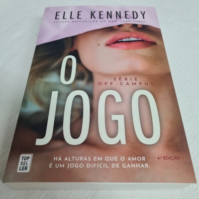 Capa de livro rosa com rosto feminino parcial e texto O JOGO de Elle Kennedy