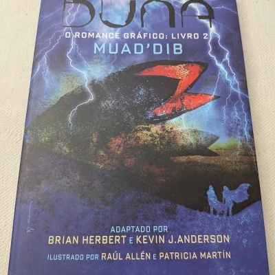 Capa do livro gráfico DUNE O ROMANCE GRÁFICO: LIVRO 2 MUADDIB com fundo azul e preta e relâmpagos