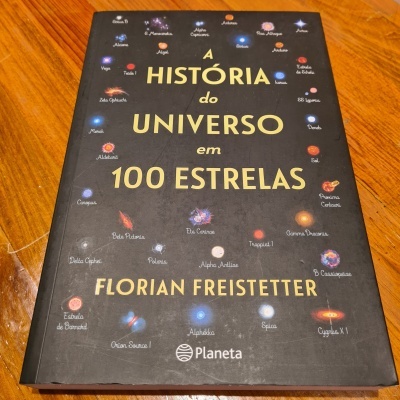Livro 'A História do Universo em 100 Estrelas' de Florian Freistetter, capa preta com estrelas coloridas