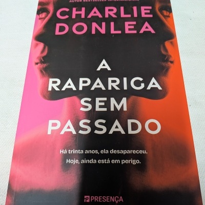Capa de livro A RAPARIGA SEM PASSADO de Charlie Donlea em cores rosa, roxo e laranja com rosto de perfil