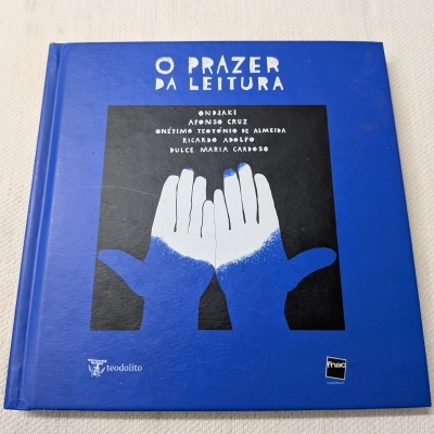 Livro de capa dura azul com título e ilustração de mãos.