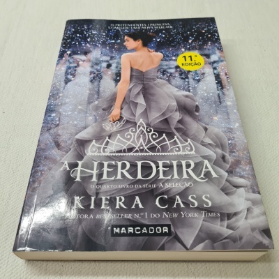 Capa do livro 'A Herdeira' mostrando mulher de vestido cinzento com etiqueta amarela 11ª EDIÇÃO