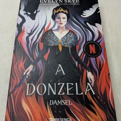Capa do livro A DONZELA de Evelyn Skye com ilustração de mulher com coroa e chamas ao fundo
