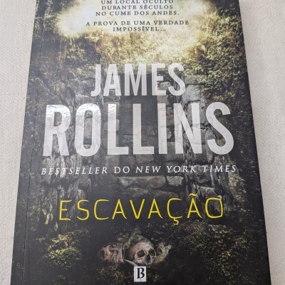 Capa do livro Escavação de James Rollins com entrada de pedra e caveiras