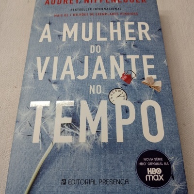 Capa de livro azul com título A Mulher do Viajante no Tempo e ícones pequenos