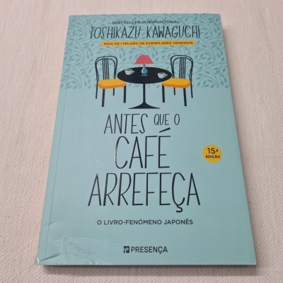 Capa de livro azul claro com ilustração de mesa e cadeiras, texto em português