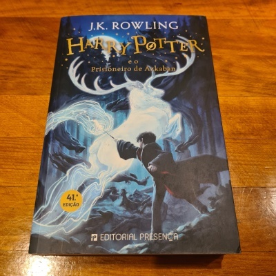 Capa do livro Harry Potter e o Prisioneiro de Azkaban com ilustração de cervo branco e personagem com varinha