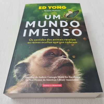 Capa do livro 'Um Mundo Imenso' com imagem de um macaco e texto em português.