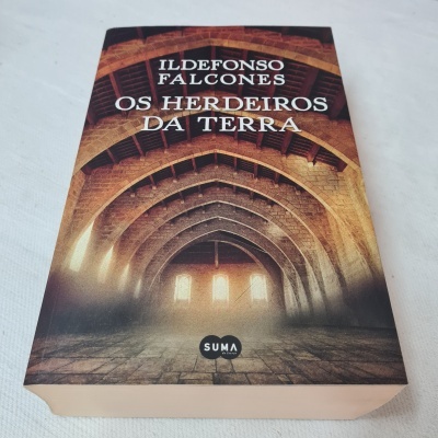 Livro 'Os Herdeiros da Terra' de Ildefonso Falcones sobre superfície branca