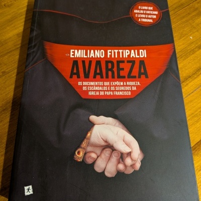 Capa do livro AVAREZA de Emiliano Fittipaldi sobre mesa de madeira
