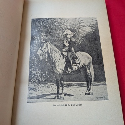 Página de livro com imagem de Dom Carlos I montado num cavalo