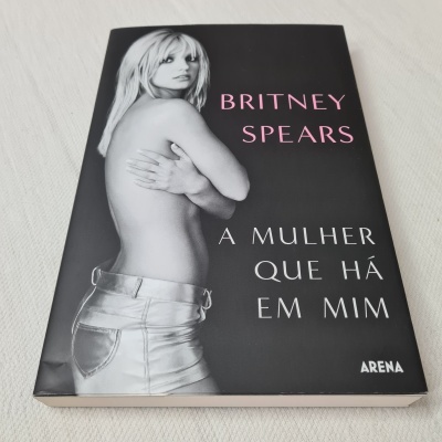 Capa de livro preta com fotografia de mulher e texto Britney Spears A Mulher Que Há Em Mim