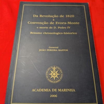 Livro preto com texto dourado num fundo vermelho.