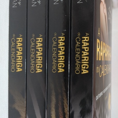quatro livros em preto com padrão de pele animal e títulos dourados