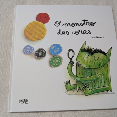 Capa de livro infantil com ilustração de monstro verde e círculos coloridos