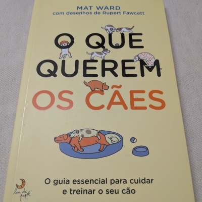 Capa de livro amarelo com título em português e desenhos de cães