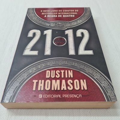 Livro '21-12' de Dustin Thomason com capa preta, cinza e vermelha