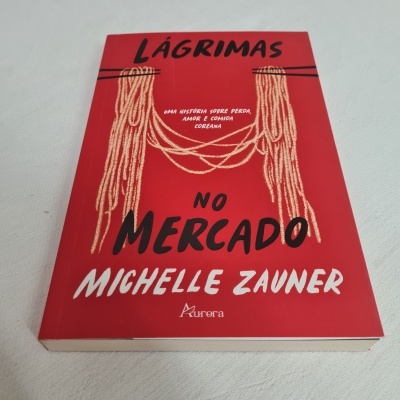 Livro 'Lágrimas no Mercado' com capa vermelha e texto em preto e branco sobre fundo branco