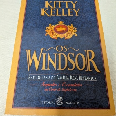 Capa do livro Os Windsor de Kitty Kelley com fundo azul escuro e bordas amarelas.