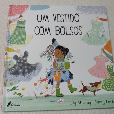 Capa de livro infantil com menina e vestidos coloridos