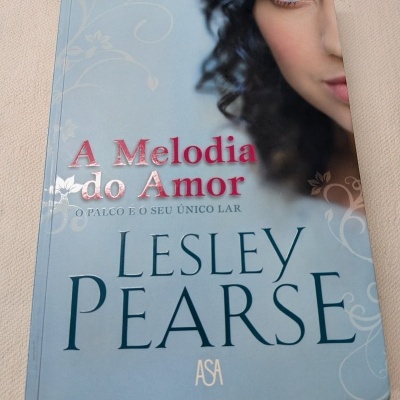 Livro A Melodia do Amor com rosto parcial de mulher e texto em destaque.