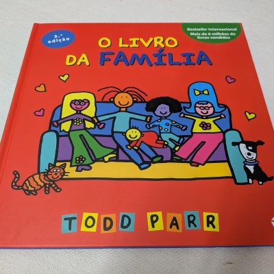 Capa de livro infantil O LIVRO DA FAMÍLIA com ilustração de família sentada no sofá