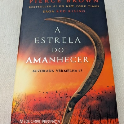 Capa de livro A Estrela do Amanhecer com céu laranja e foice