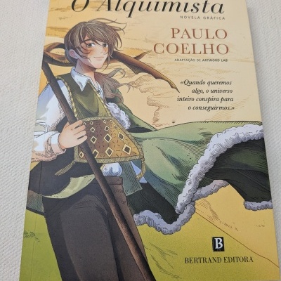Capa do livro O Alquimista de Paulo Coelho com ilustração de personagem e texto