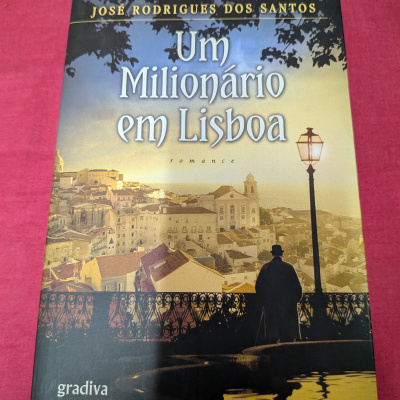 Capa de livro Um Milionário em Lisboa com imagem de Lisboa ao fundo ao entardecer
