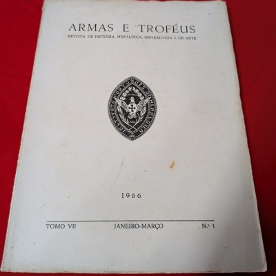 Capa de revista branca com texto em preto e emblema central, sobre fundo vermelho