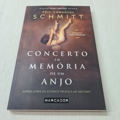 Livro Concerto em Memória de um Anjo de Éric-Emmanuel Schmitt com capa castanha e texto branco e dourado