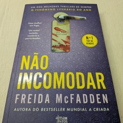 Capa de livro roxa com título NÃO INCOMODAR em amarelo e imagem de pendurador de porta