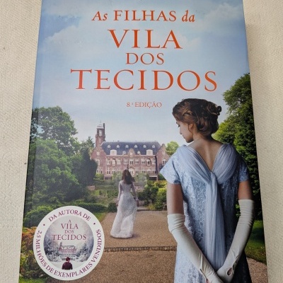 Capa de livro com mulheres em vestidos elegantes e mansão ao fundo