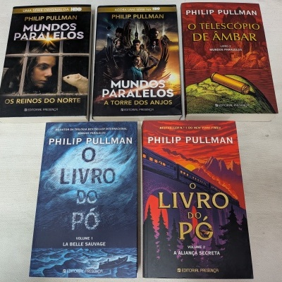 Cinco livros de Philip Pullman com títulos e capas distintas sobre uma superfície branca.