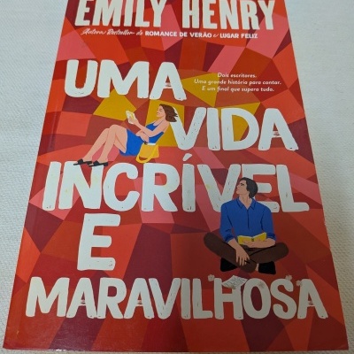 Capa de livro vermelho com letras brancas e desenhos de homem e mulher a ler.