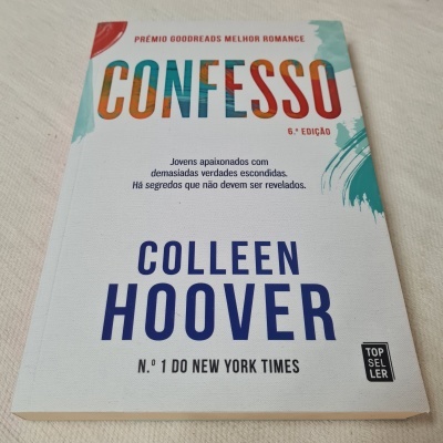 Livro Confesso de Colleen Hoover com capa branca e texto colorido