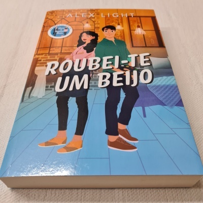 Livro 'ROUBEI-TE UM BEIJO' de Alex Light com ilustração de um homem e uma mulher em ambiente interior