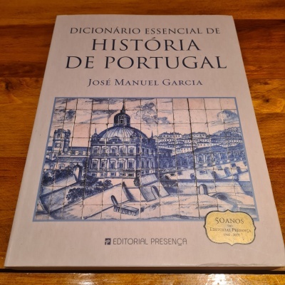 Capa do livro 'Dicionário Essencial de História de Portugal' com ilustração de azulejos e selo amarelo dos 50 anos da editorial