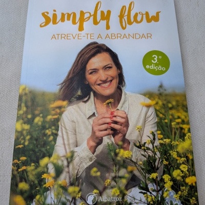 Capa do livro simply flow de Fátima Lopes com a autora segurando flor num campo