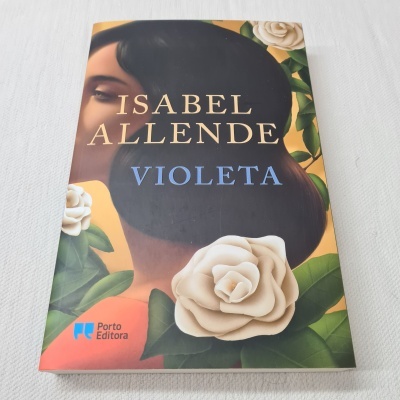 Capa do livro 'Violeta' de Isabel Allende com ilustração de mulher e flores brancas