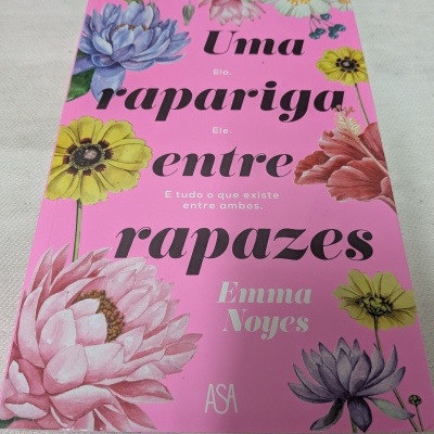 Capa de livro rosa com flores e texto Uma rapariga entre rapazes