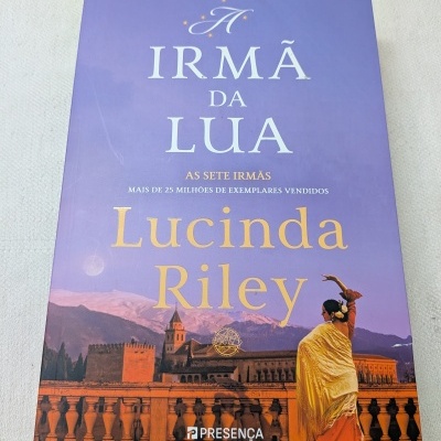 Capa do livro A Irmã da Lua de Lucinda Riley com imagem de mulher e cenário urbano