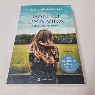 Capa do livro 'GANHEI UMA VIDA QUANDO TE PERDI' de Raul Minh'Alma com mulher de costas num campo verde