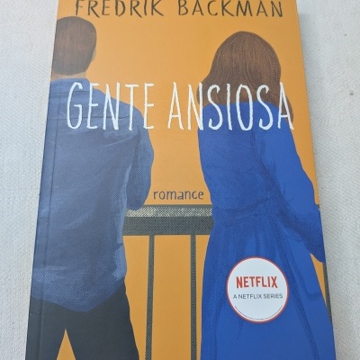 Capa do livro Gente Ansiosa com ilustração de duas pessoas de costas e selo Netflix